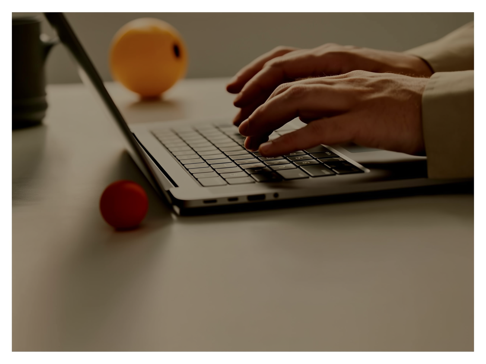 Manos trabajando en un ordenador portátil con elementos que sugieren estrés laboral