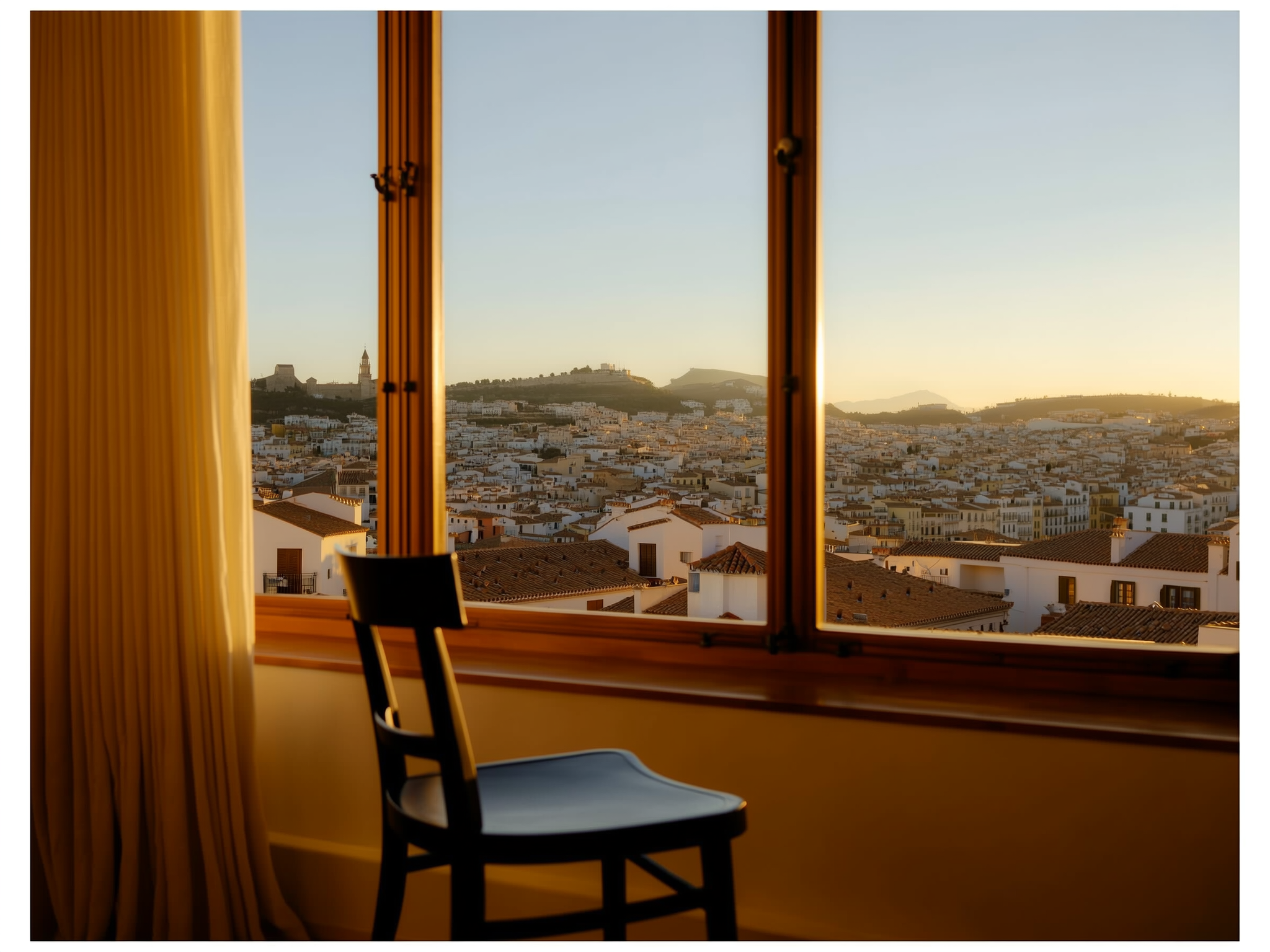 Persona joven contemplando el horizonte desde una ventana con luz suave, transmitiendo calma y reflexión