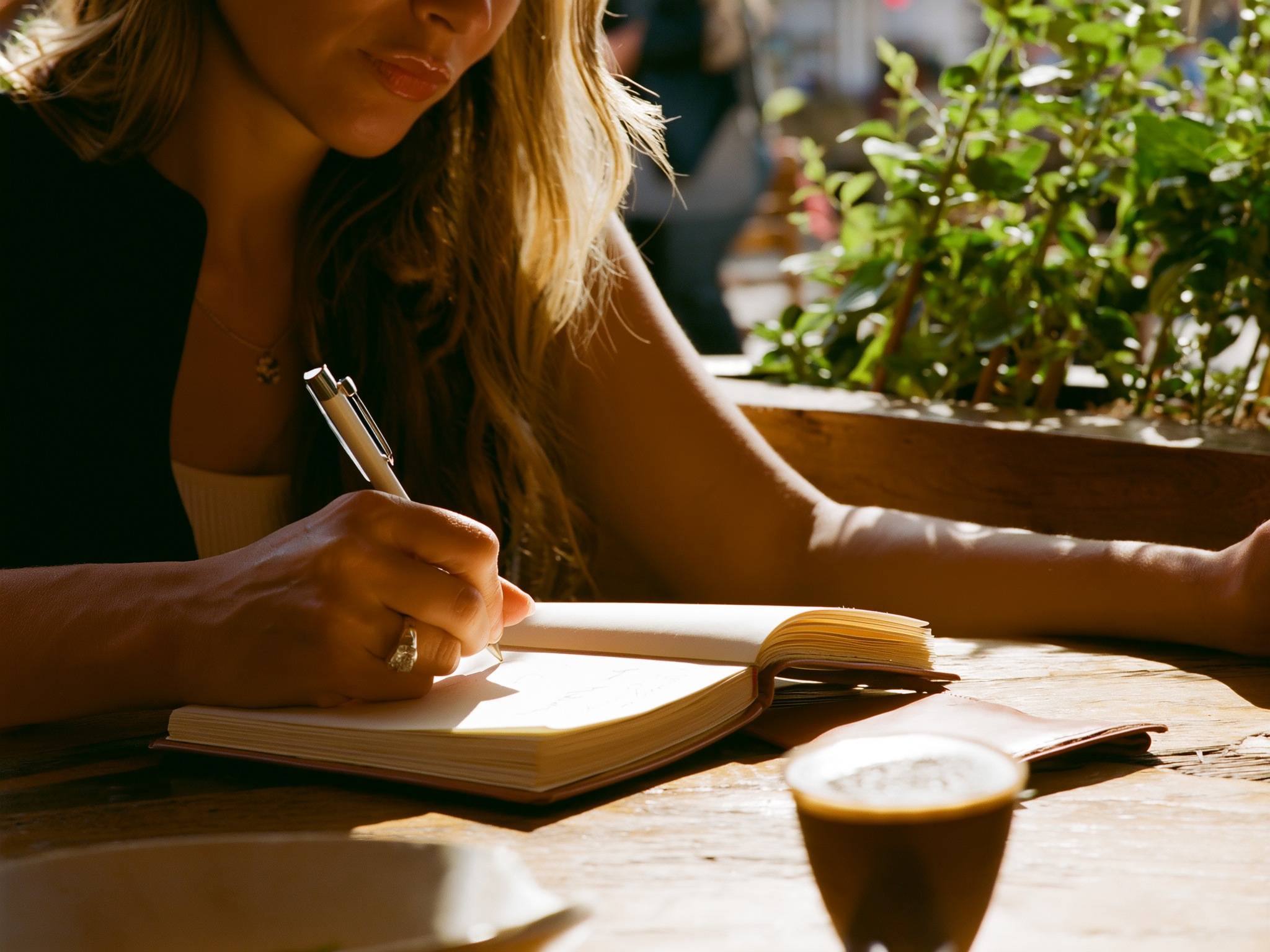 Manos escribiendo en un diario personal, representando la introspección y autoconocimiento
