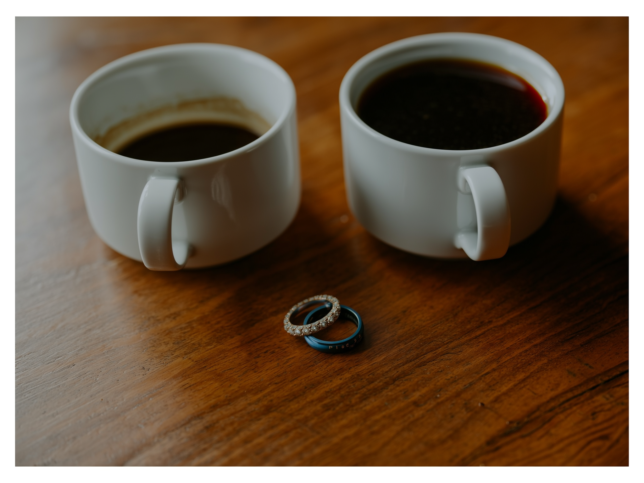 Anillos de matrimonio junto a tazas de café sin tocar simbolizando la desconexión en pareja