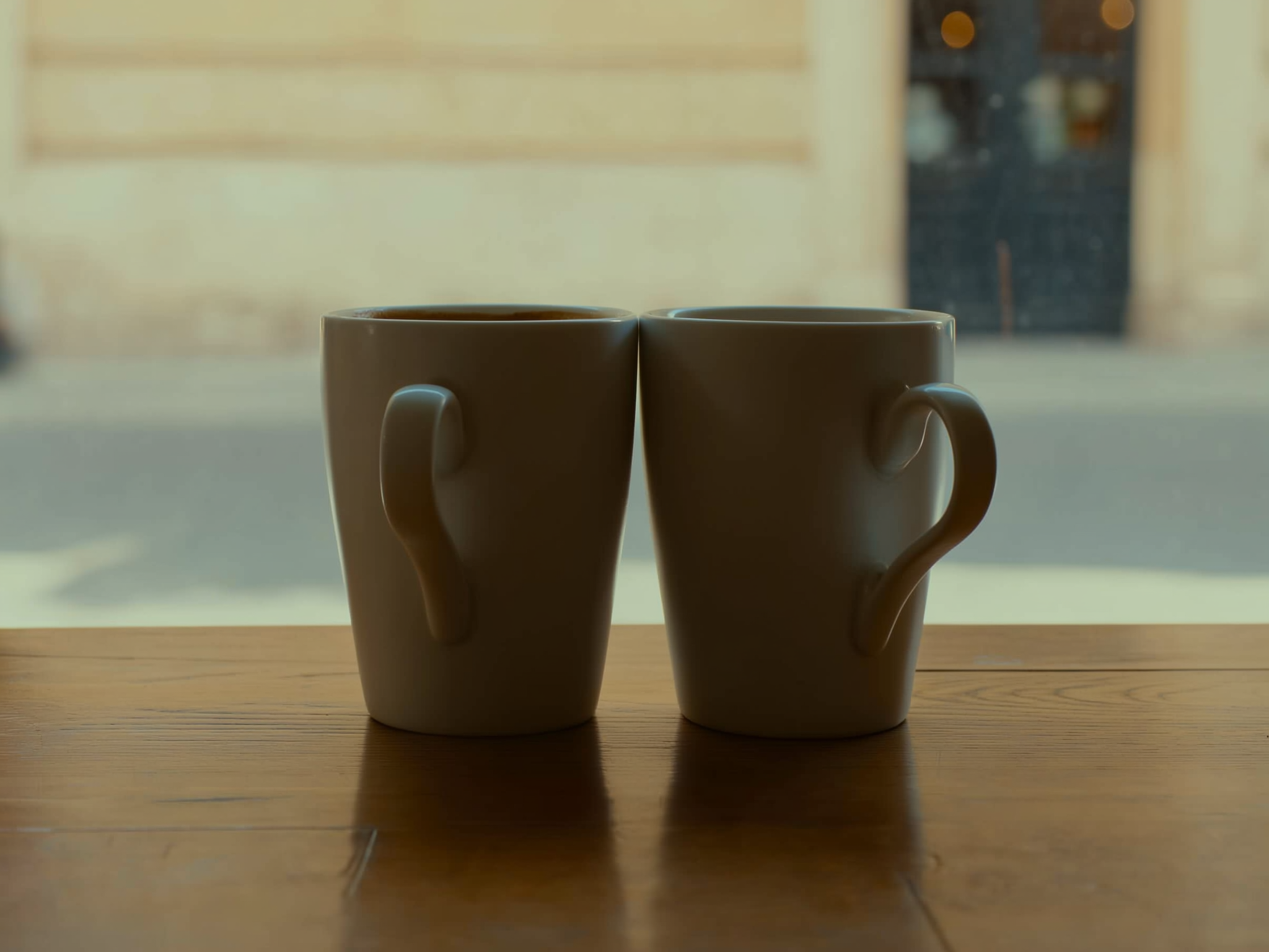 Dos tazas de café separadas en una mesa, simbolizando la distancia emocional en las relaciones