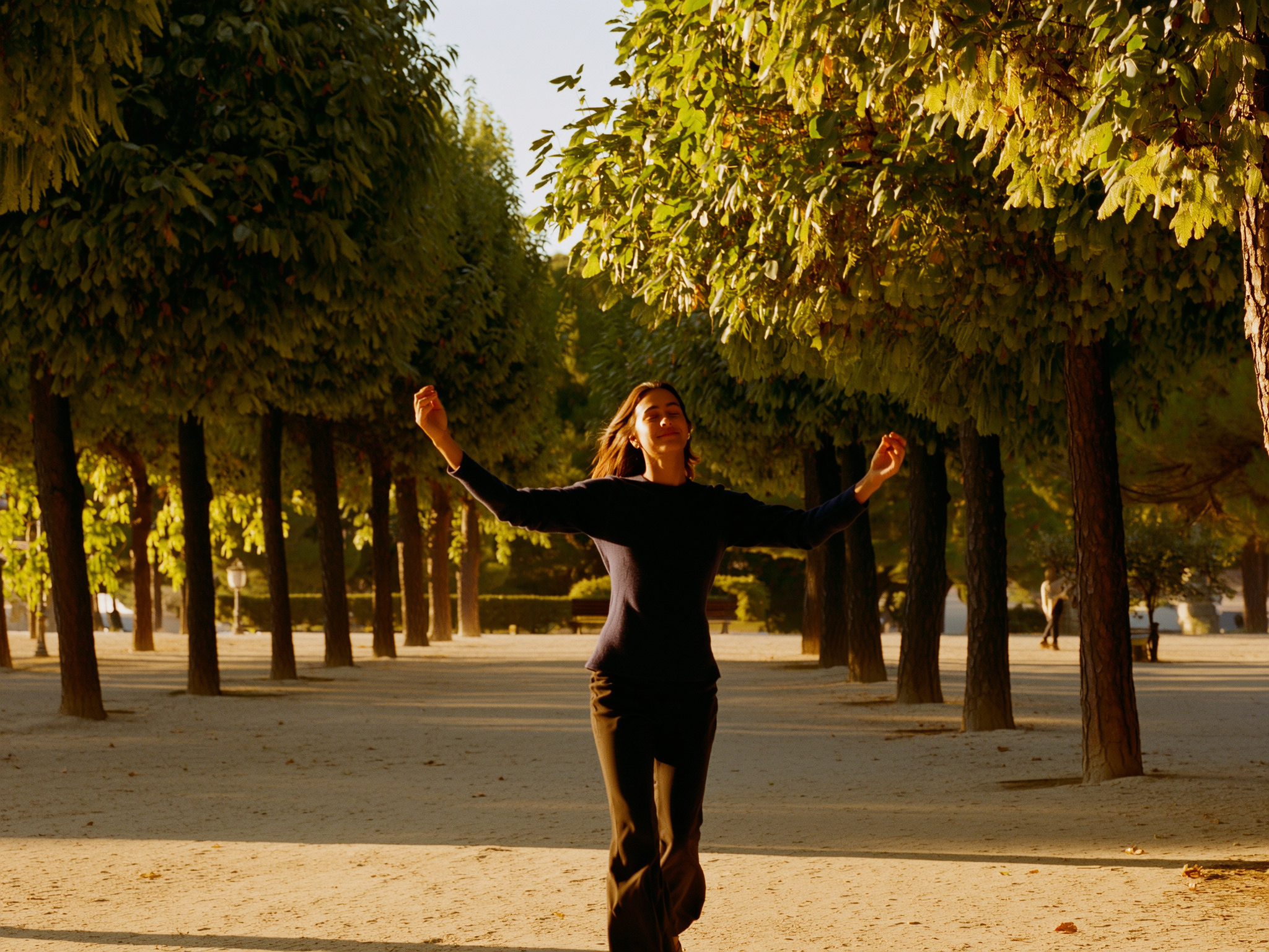 Persona caminando tranquilamente por un parque europeo al atardecer