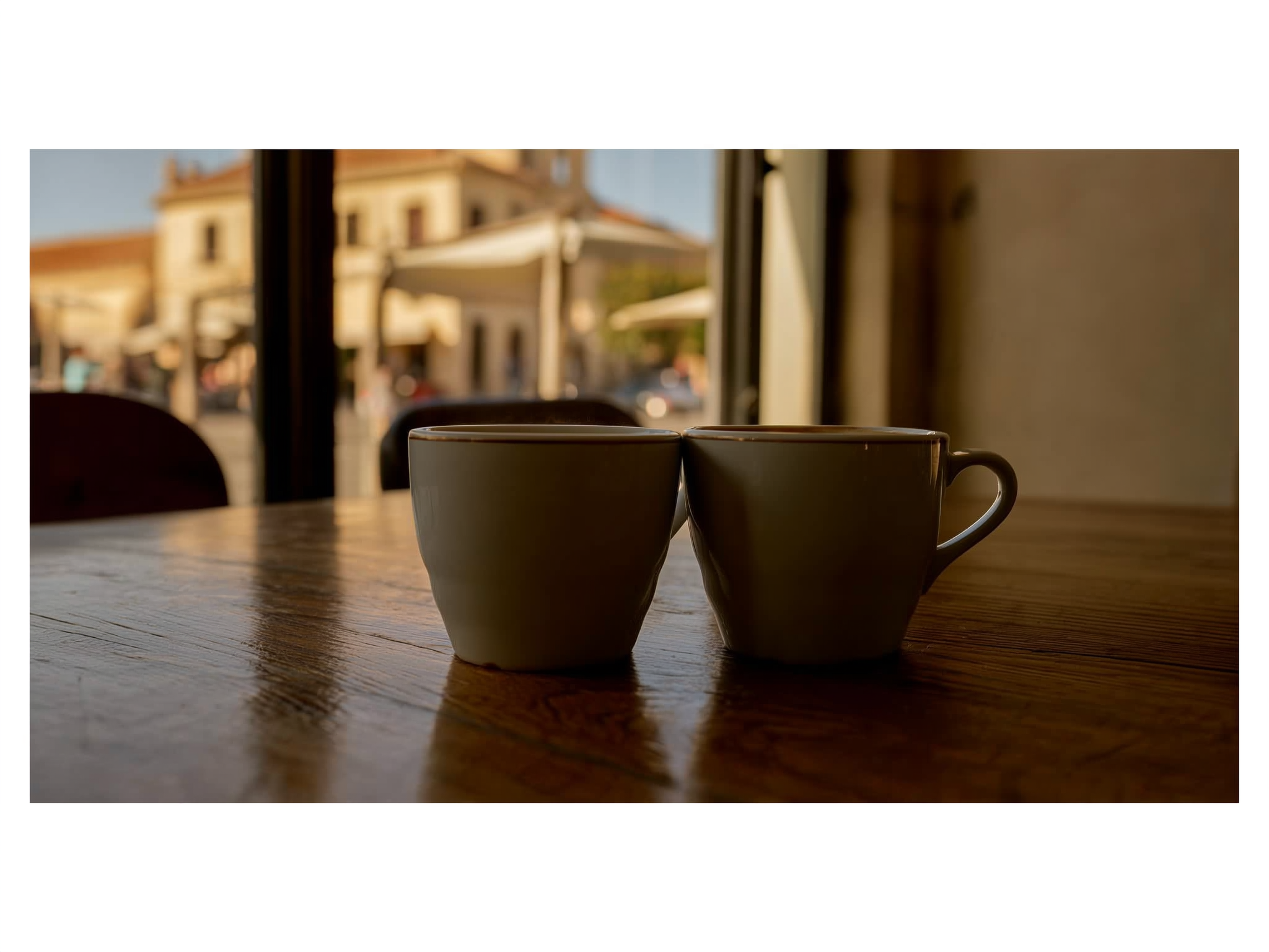Dos tazas de café separadas sobre mesa de madera representando distancia emocional en pareja