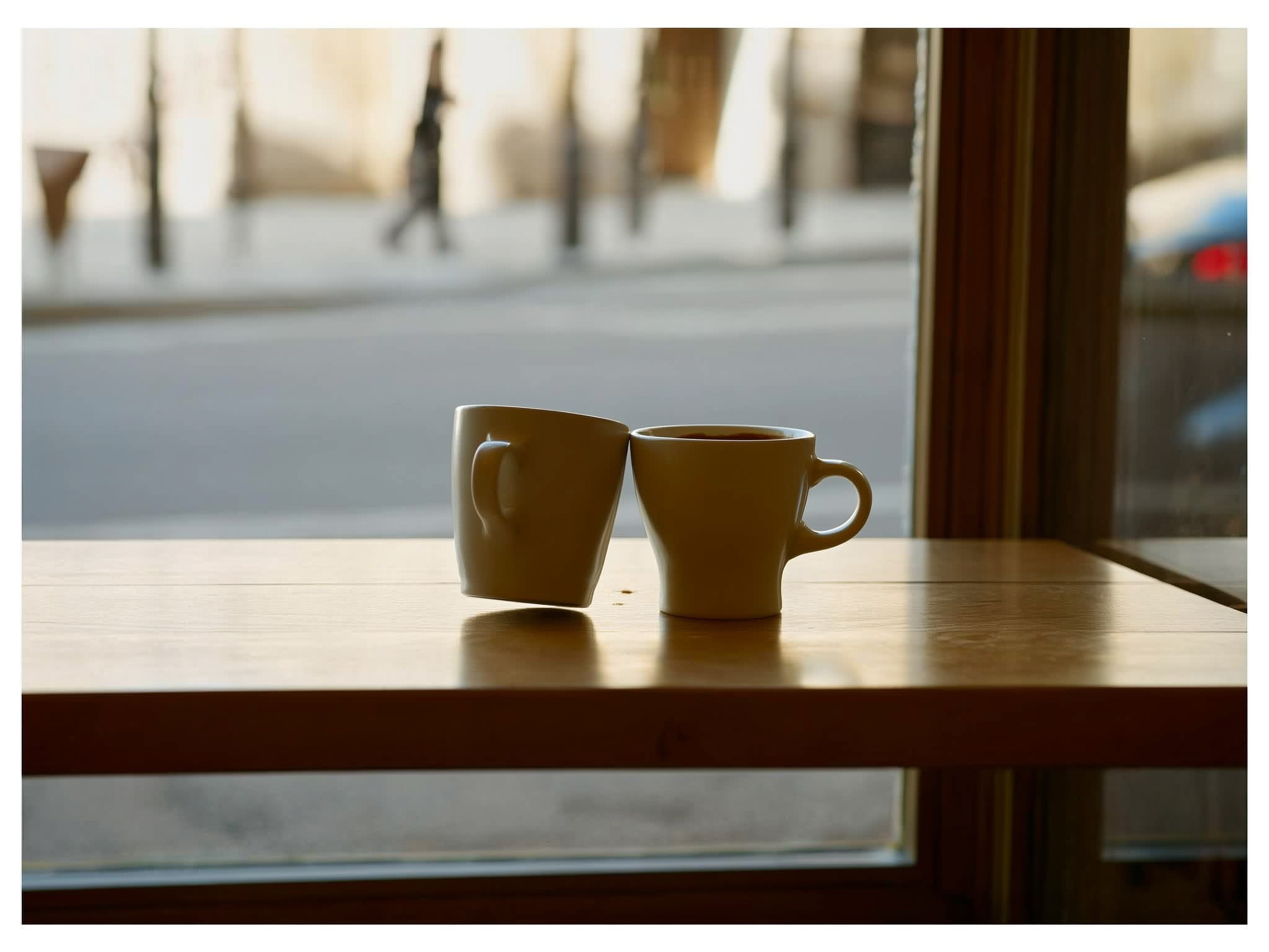 Dos tazas de café separadas en una mesa, representando la distancia emocional en las relaciones