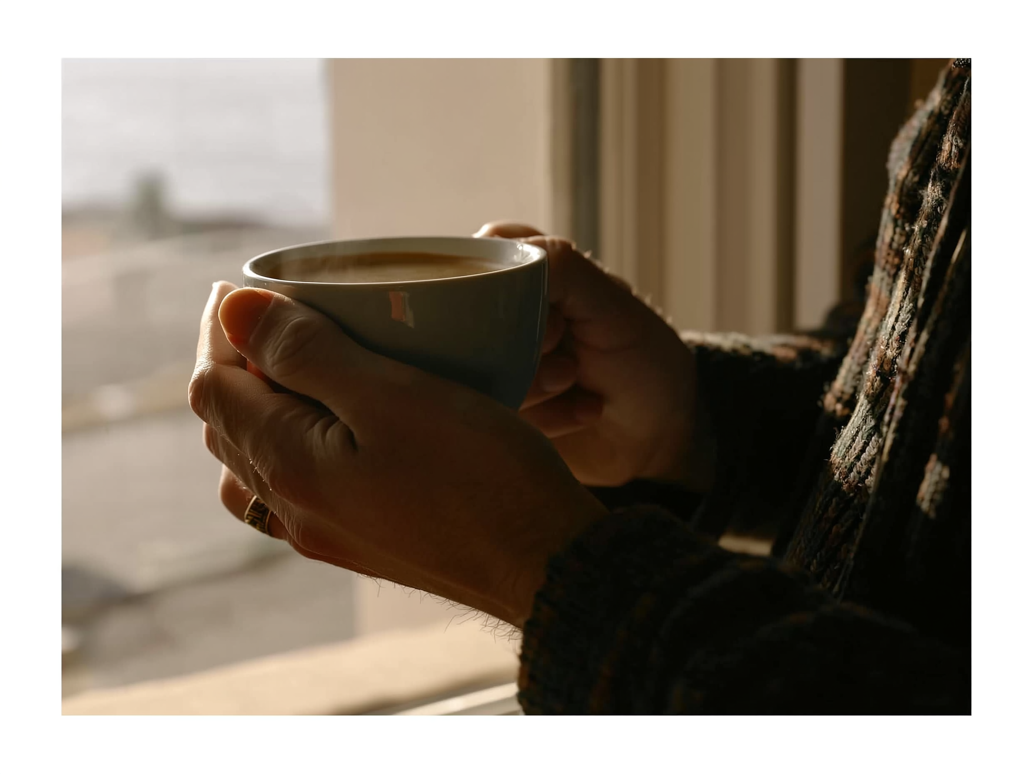 Manos adultas sosteniendo una taza en momento de pausa y reflexión