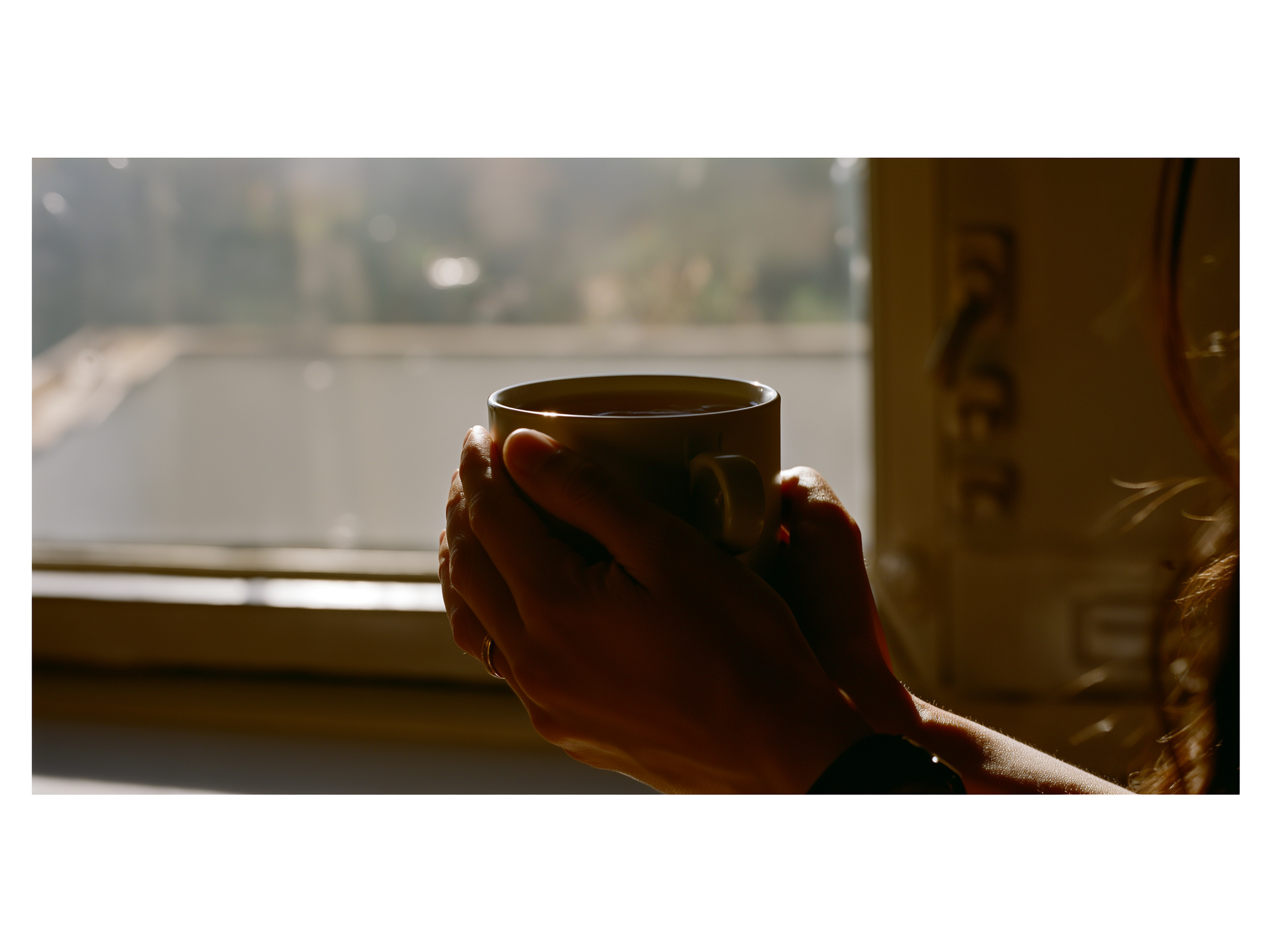 Manos sosteniendo una taza en un momento de calma y reflexión