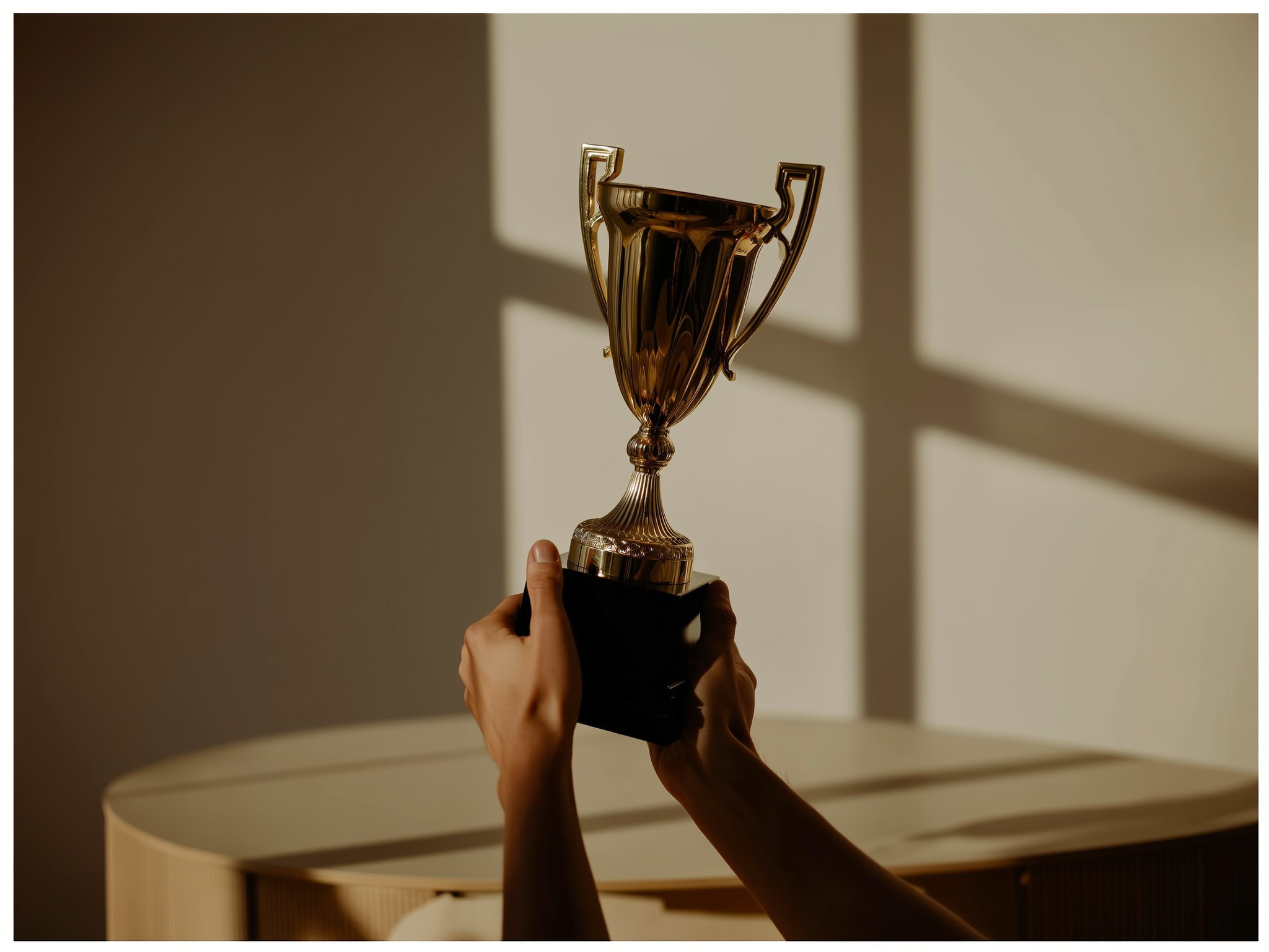 Manos sosteniendo un trofeo vacío sobre un escritorio, simbolizando logros sin significado